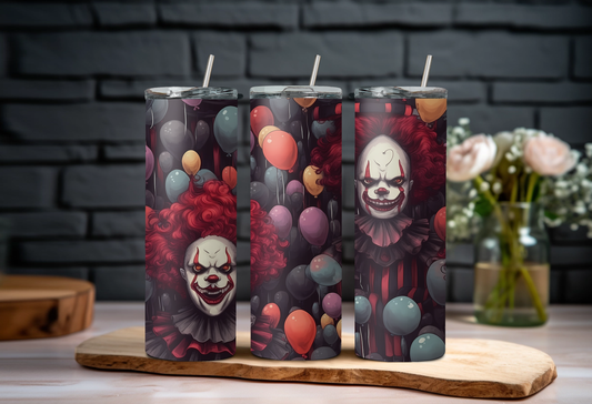 Three tumblers with clown-themed designs on a wooden board against a dark brick wall.